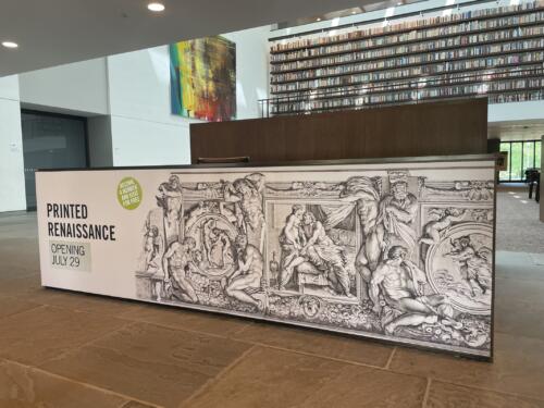 Wide format mural for museum installed at front desk promoting upcoming exhibit