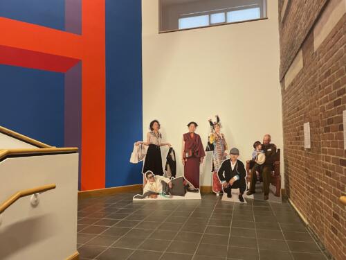 Fine art museum installation using life-size human cutouts displayed in stairwell