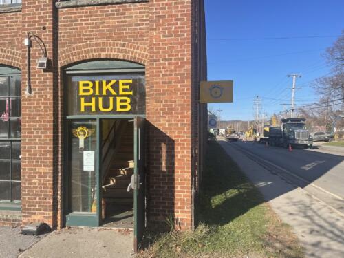 Window graphics for Bennington bicycle shop. Yellow vinyl lettering adhered to transom reads "Bike Hub" with cut vinyl logo below
