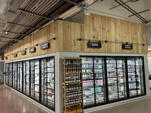 Hanging sign frames identifying refrigerator sections.